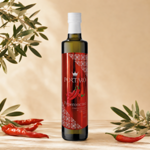 Oliwa Peperoncino Portaro na ciepłym tle z papryczkami chili i liśćmi oliwnymi - Calabrisella