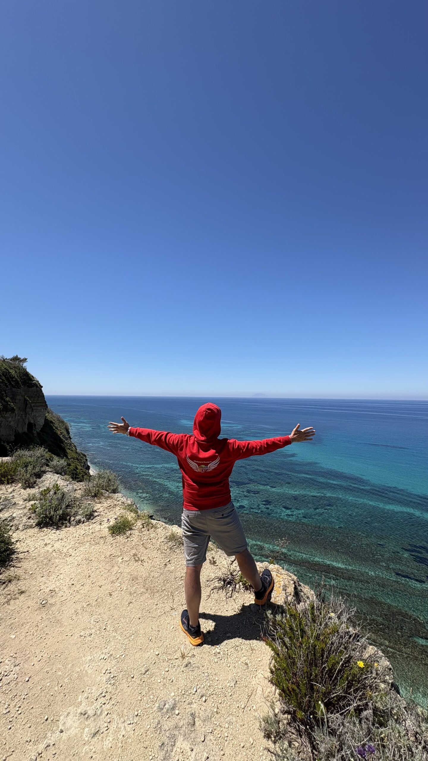 Piotr Jawornik na klifie nad Morzem Tyrreńskim — spojrzenie ku Stromboli i Wyspom Liparyjskim — fot. © Piotr Jawornik