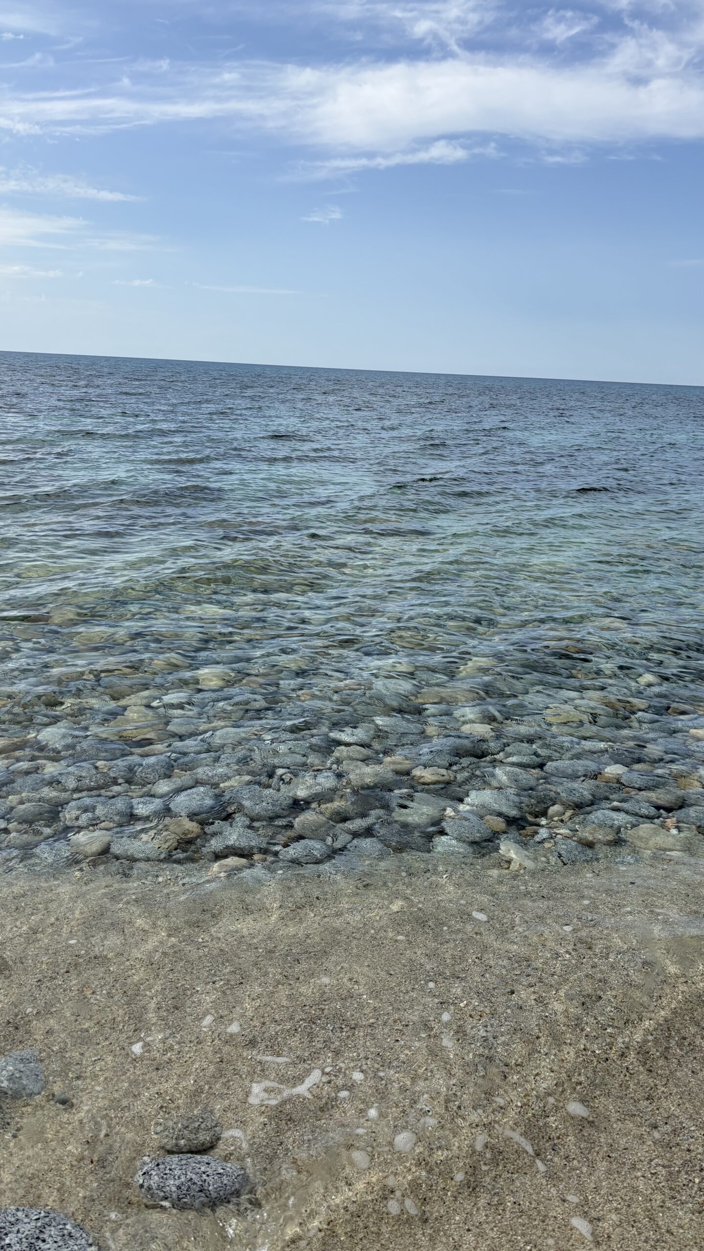 Kamienista plaża z krystalicznie czystą wodą — fot. © Piotr Jawornik