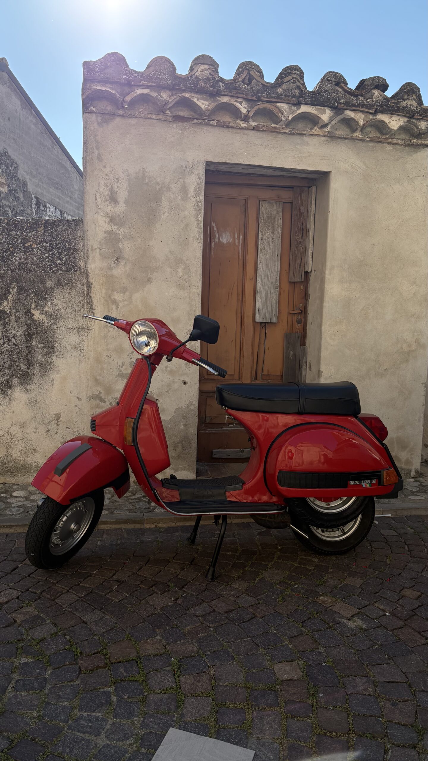 Czerwona Vespa PX 125 przy starej kamienicy — fot. © Piotr Jawornik